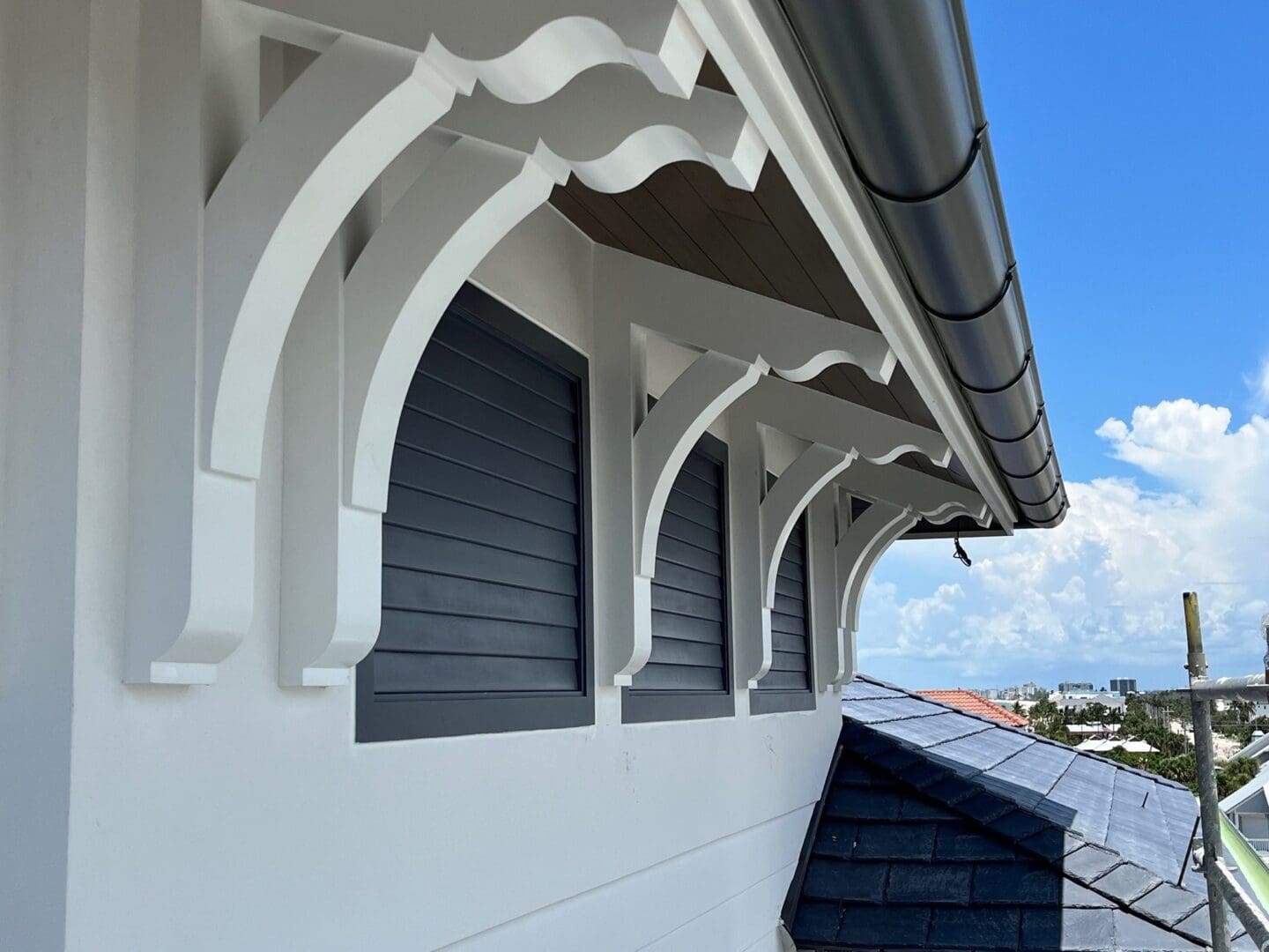Decorative roof brackets on white building exterior.