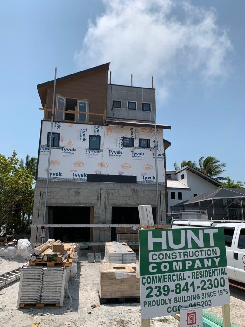 A building under construction with a sign in front of it.